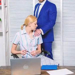 A man in a suit standing behind a woman at a desk, with his hand on her shoulder, Indecent Liberties Arrest