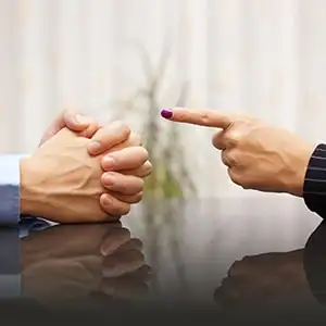 Accusation image: Finger pointing at clasped hands, related to sex crime defense in Kansas.