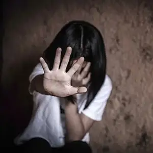 A person holding their hand up in a defensive "stop" gesture.